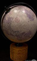 Front view of globe showing map colors and wooden base
