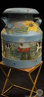 Full view of milk can on stand showing sunflower and farm scene