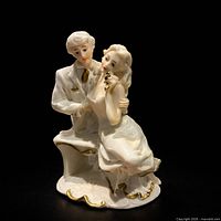 Front view of porcelain courting couple figurine displaying overall form and gold accents