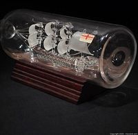 Full view ship in bottle on wood base