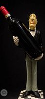 Front view of sommelier sculpture holding oversized wine bottle