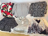 All six tops laid out showing front designs and colors