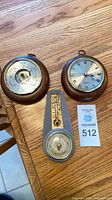 Group shot of all three pieces: wood barometer, wood quartz clock, grey thermometer-barometer