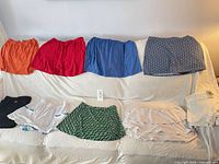 Nine garments displayed on sofa showing colors and styles