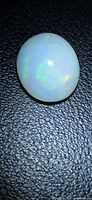 Top view of oval opal showing white body and colour flashes