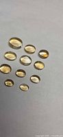 All ten oval cabochon citrine gemstones displayed on neutral background