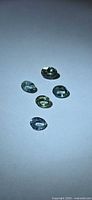 Five oval green sapphires on white background