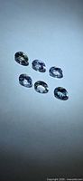 Six oval Tanzanite stones on white background