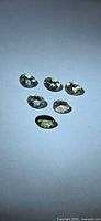 Six oval cut pale green tanzanites on white background