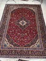 Full view of Kashan Persian rug showing overall pattern and border