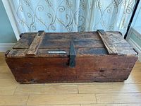 Full view of closed wooden trunk on floor