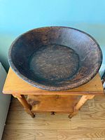 Top view of round wooden dough bowl on table