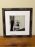 Full view of framed Banksy print on tabletop
