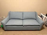 Full frontal view of blue two-seat sofa bed