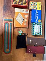 Overall lot layout showing Yahtzee, card cases, cribbage board, checkers box, sealed games, dice pouch