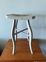 Full view of gray-blue wooden stool on table