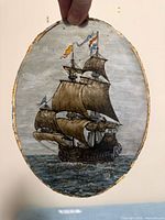 Full view of oval glass plaque held up to light