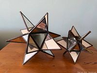 Two mirrored glass star candle holders on table