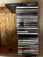 Full stack of approximately 25 CD jewel cases showing visible titles
