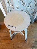 Top and legs of white wood stool showing dimensions noted on seat