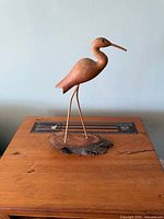 Full view of carved bird sculpture on base