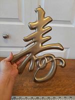 front view of brass Shou symbol wall hanging