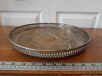 Side view of round silverplated tray showing pierced gallery and scale