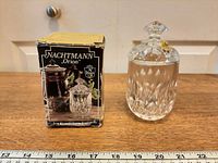 Jar with lid beside original box, ruler for scale