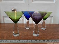 Four coloured martini glasses front view