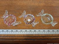 Three glass tealight holders in candy shape with ruler for scale