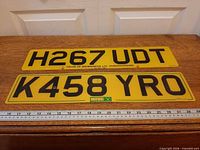 Both yellow UK number plates side by side showing full characters and size reference