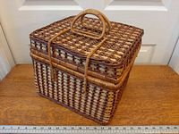 Front angled view showing basket shape, weave, handle over lid