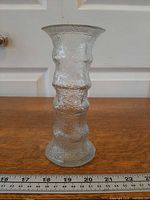 Side view of the clear crinkle ice glass vase showing full height and texture beside ruler