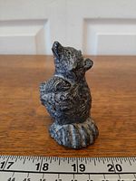 Front angled view of Wolf Originals bear cub figurine beside ruler