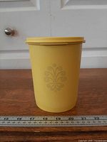 Side view of yellow canister showing embossed motif