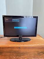 Front view of Samsung 24-inch TV powered on displaying no signal message