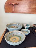 Group view of blue floral bowls, small teal bowl and lidded jar
