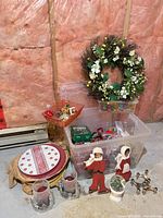 Group shot showing wreath, charger plates, wooden figures, candle holders, decorative jacks and tote of ornaments