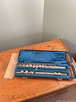 Flute parts in closed hard case on wooden table