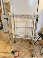 Front view of chrome wire cart with 3 levels and casters