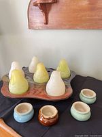 Front view showing seven pear candles on multicolour tray with five ceramic holders in foreground