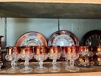 Ruby red goblets, plates, bowls on shelf