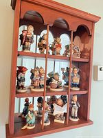 Front view of wooden wall shelf with all twelve figurines displayed