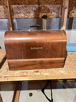 Front view of wooden Singer sewing machine carrying case