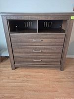 Front view showing open shelf, three drawers, overall finish