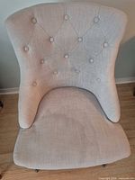 Front view of upholstered accent chair showing tufted back and seat