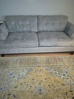 Front view of light gray 3-seat sofa showing overall design and dark wood legs