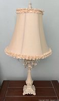 Full view of first cream Victorian-style table lamp with shade and crystal prisms