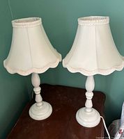 Pair of matching white lamps on tabletop