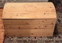 Front view of solid pine chest showing domed lid and plank construction